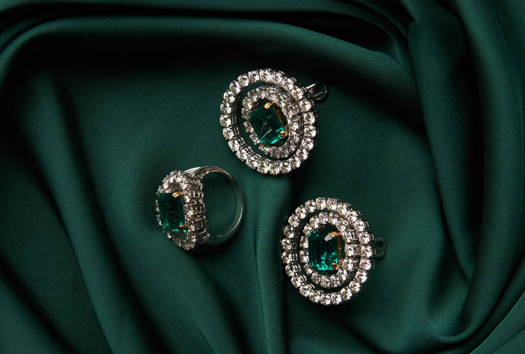 Three Emerald and Diamond Rings on Green Cloth